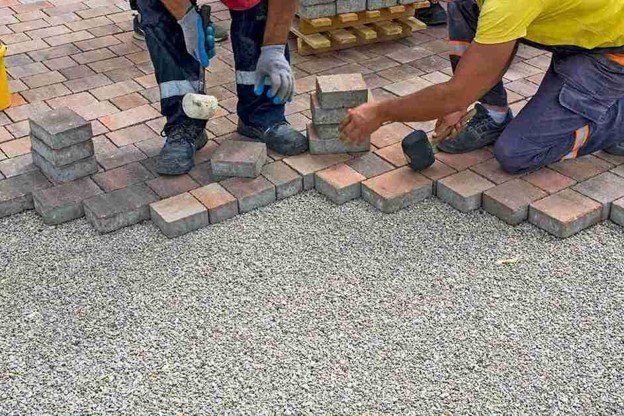 Concrete contractors installing paver driveway edge with gravel base preparation in Columbia Station, OH