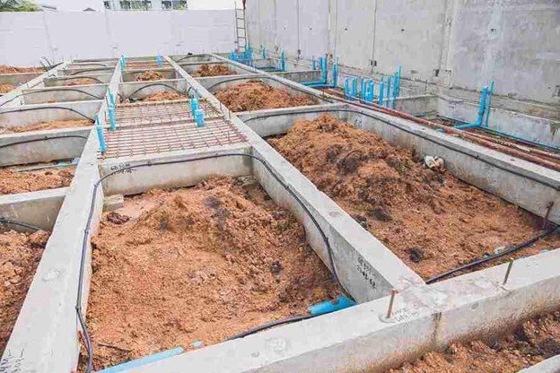 Concrete foundation installation with footing layout and plumbing lines prepared for residential build in Columbia Station, OH