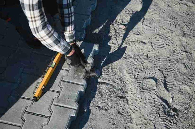 Stamped concrete installation with worker shaping and finishing textured surface in Columbia Station, OH