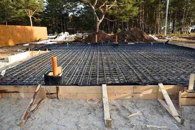 Concrete slab preparation with steel rebar reinforcement grid before pouring foundation in Columbia Station, OH