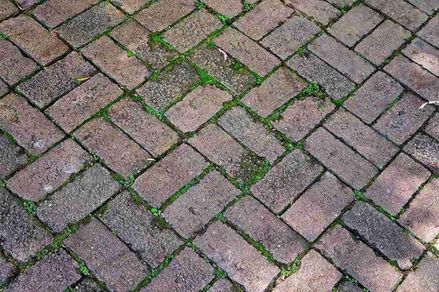 Uneven patio surface with shifting pavers and gaps before concrete patio replacement in Columbia Station, OH